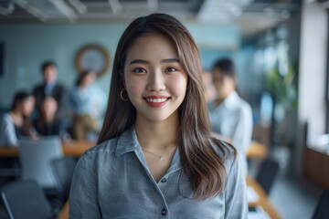 Naklejka premium Confident Asian businesswoman in modern office with colleagues.