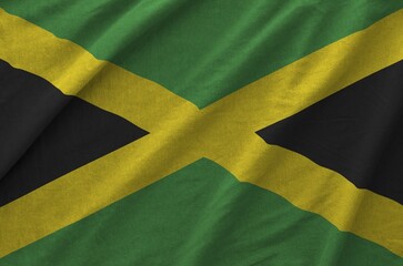 Jamaica flag depicted on folded wavy fabric of old cloth close up