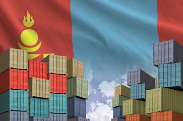 Mongolia flag and big stack of shipping cargo containers in docks with sky background close up