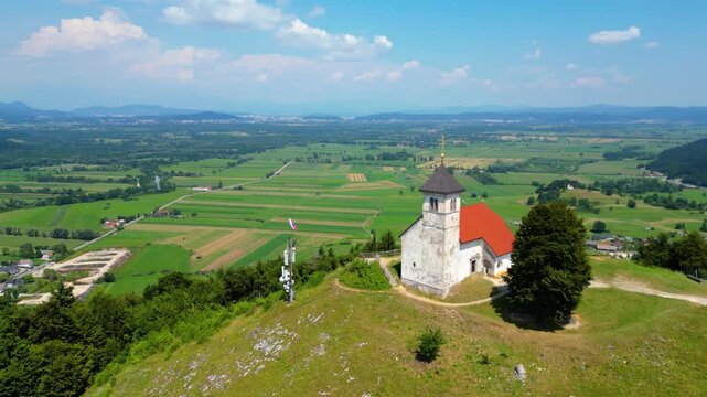 A stunning aerial view of Cerkev sv. Ane, Jezero, and Jezero pri Podpeči in Slovenia, captured by a drone. This captivating image showcases the picturesque church of St. Anne, serene lakes