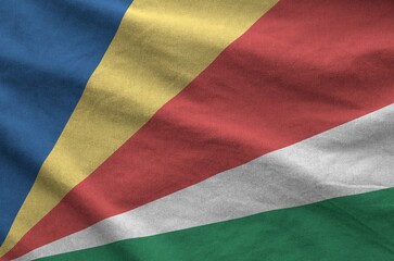Seychelles flag depicted on folded wavy fabric of old cloth close up