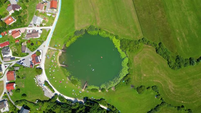 A stunning aerial view of Cerkev sv. Ane, Jezero, and Jezero pri Podpeči in Slovenia, captured by a drone. This captivating image showcases the picturesque church of St. Anne, serene lakes