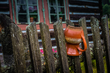 An old wooden fence with a clay pot.
