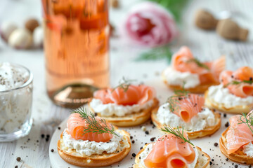 Smoked salmon blinis with cream cheese, fresh dill and a bottle of prosecco blurred in background