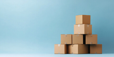  A neatly stacked pile of cardboard boxes on a plain blue background, symbolizing moving or storage organization. Copyspace.