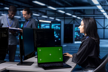 Computer scientist using green screen notebook to oversee blade servers used for managing...
