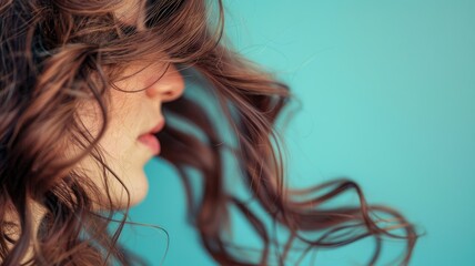 Naklejka premium Portrait of woman with brown curly hair against turquoise background