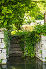 Obraz premium Charming stone steps leading to a lush garden, surrounded by greenery and tranquility in the historic village of Chateau Landon