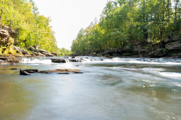 Obraz premium A gorgeous view of water near trees and plants at a local park in Minnesota.
