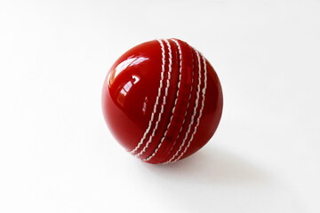 closeup shiny red cricket ball on white background