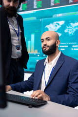 Financial analyst works on resource allocation plans with his staff, analyzing reports and sales...