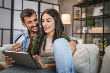 Adult couple buy online on digital tablet with credit card at home