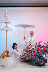 full length couple of lovers, a young indonesia boy and girl happy, are slumped on the floor, a man...