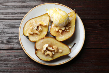 Delicious baked pears with nuts, ice cream and honey on wooden table, top view