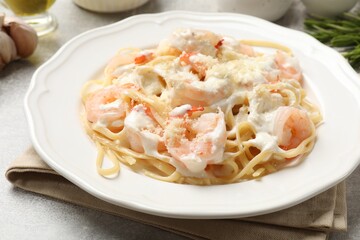 Delicious pasta with shrimps served on light table, closeup