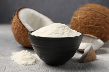 Coconut flour in bowl and fresh fruits on light grey table, closeup