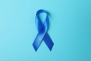 Blue ribbon on color background, top view. Prostate cancer awareness