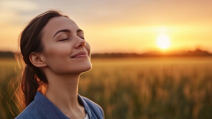 Backlit Portrait of calm happy smiling free woman with closed eyes enjoys a beautiful moment life on the fields at sunset