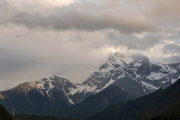 Fototapeta premium The snow-capped mountains are shrouded in clouds
