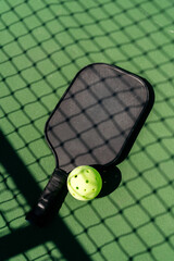 closeup of pickleball paddle and pickleball net on a court