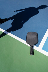 man playing pickleball on sunny day with paddle on a pickleball court