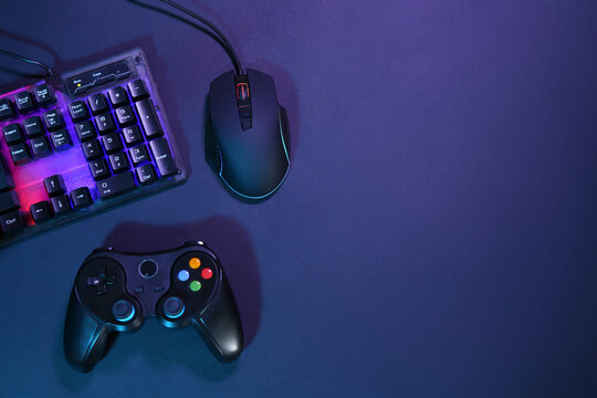 Computer mouse, RGB keyboard and game controller on dark background, flat lay. Space for text - Powered by Adobe