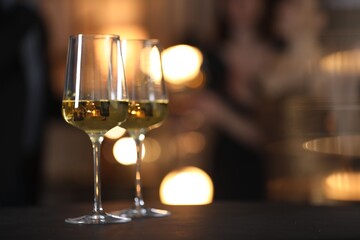 Tasty wine in glasses on black table indoors, selective focus