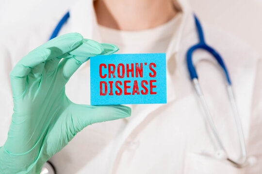 Doctor holding a card with diagnosis words Crohn's disease.
