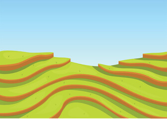 Green rice paddies forming steps all the way up on the hill under a clear blue sky