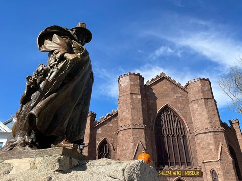 A sculpture of Roger Conant, the founder of Salem Massachusetts, stands in front of the witch museum, once a former church