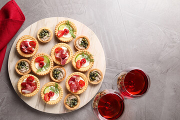 Delicious canapes served on grey textured table, flat lay