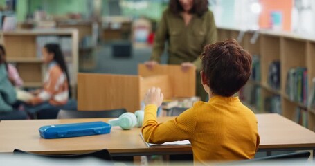 Hand, back and child with question in library for studying, help and academic support at school. Student, learning and boy with gesture at desk for homework feedback, education or assistance of tutor