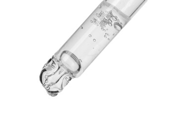 Dripping cosmetic serum from pipette on white background