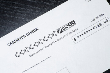 Close up of a bank cashiers check isolated on black