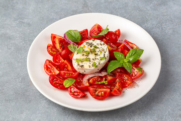 Italian caprese salad with sliced tomatoes, mozzarella, basil, olive oil