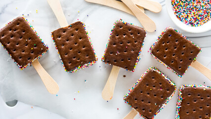 Top down view of ice cream sandwich pops with colourful sprinkles.