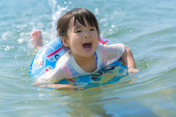 夏休みに海水浴をして遊ぶ女の子