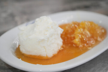 butter cream and honey in a bowl on table .