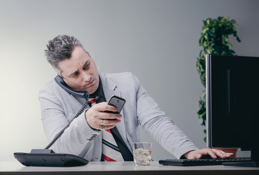 Businessman juggling devices feeling overwhelmed at work - Powered by Adobe