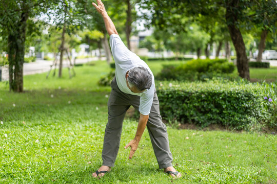 Elderly man exercising outdoors in green park, smiling and enjoying workout, demonstrating a positive and healthy lifestyle in his senior years, fitness, wellness and outdoor activities older adults