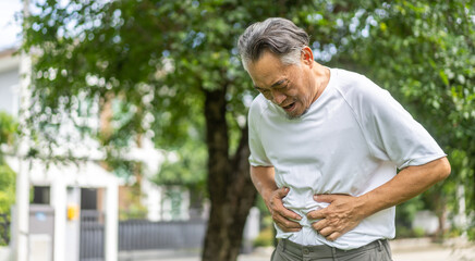 Senior asian elderly man sick unhappy touching belly stomach with suffering from stomach ache pain,...