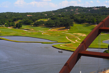 Fototapeta premium A calm lake and a maze of cart paths border the expansive golf course at the foot of the hills. It is a scenic haven for golfers and nature lovers alike.
