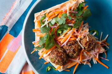 Brightly Colored Pork Meatball Vietnamese Bahn Mi Sandwich with cilantro, carrot, raddish and jalapeno