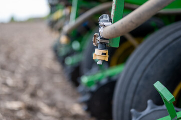 Selective focus on the spay nozzle of a chemical applicator in an agricultural field. 