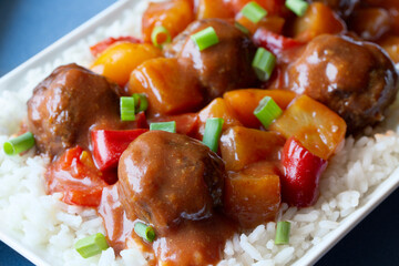 Close-up of Sweet and Sour Meatballs with Pineapple, Peppers, Green Onion Scallions and Rice