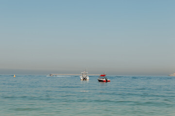 Boats anchored on calm sea with a distant horizon