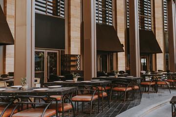 Outdoor seating area of a modern restaurant with stylish furniture and table settings