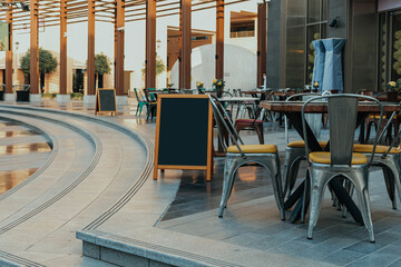 Curved outdoor dining area with modern seating and blank menu boards