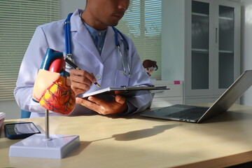 A female nurse works at a desk in an office, focusing on diagnosing and treating cardiovascular diseases. in heart conditions like cardiac arrest, stroke, and hypertension