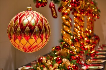 Hanging glimmering gold and red ball christmas ornament decoration